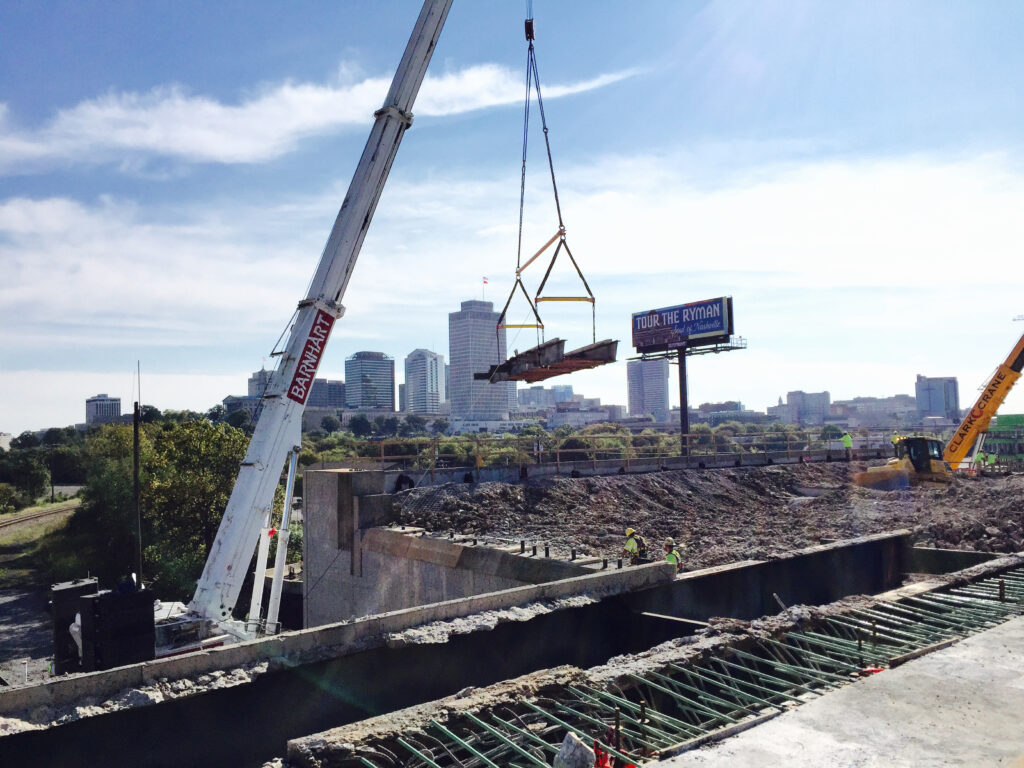After the bridge deck is demolished, existing steel girders are picked from the original structure.