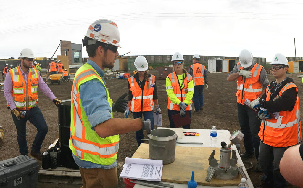 Employees observe a concrete material test demonstration during Concrete and Formwork Technical School.