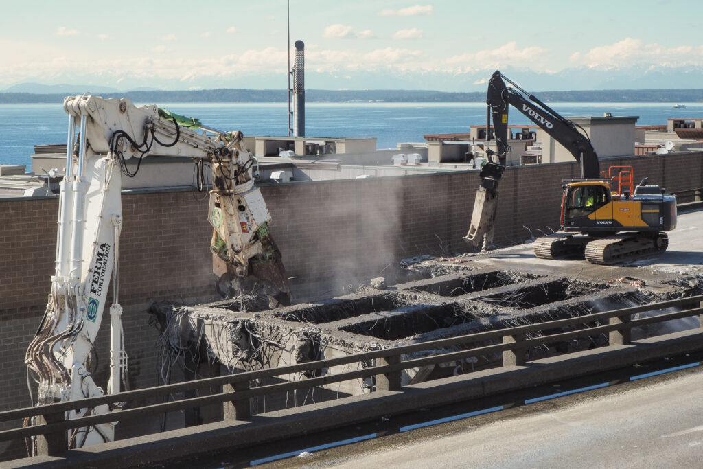 Specially designed excavators with universal processor attachments were used to break down bigger portions of the bridge while the more delicate work was handled by sawcutting and picking. 