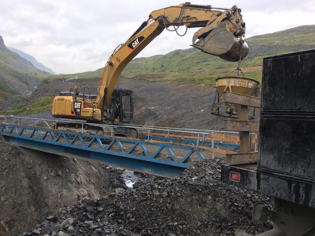 An excavator crosses over a temporary jimbob bridge. The bridge, along with all of Kiewit's equipment, leaves the island when the project finishes. 