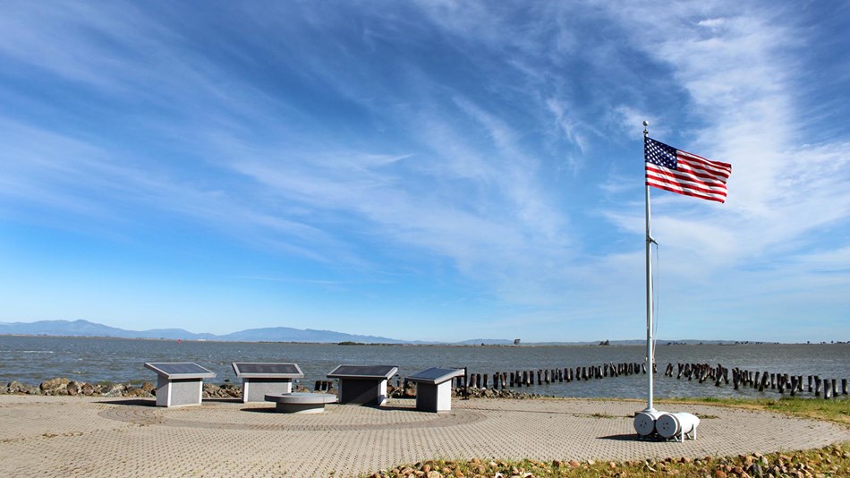 The Port Chicago Naval Magazine National Memorial is visible in the background, just north of the job site. Established in 1992, the memorial marks the final resting place of those unrecovered after an explosion on July 17, 1944.