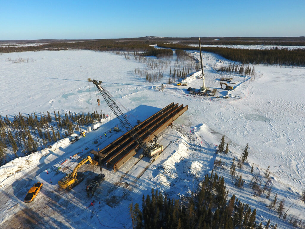 Crews use a 250-ton crane to launch a 58-meter span bridge over the LaMartre River.