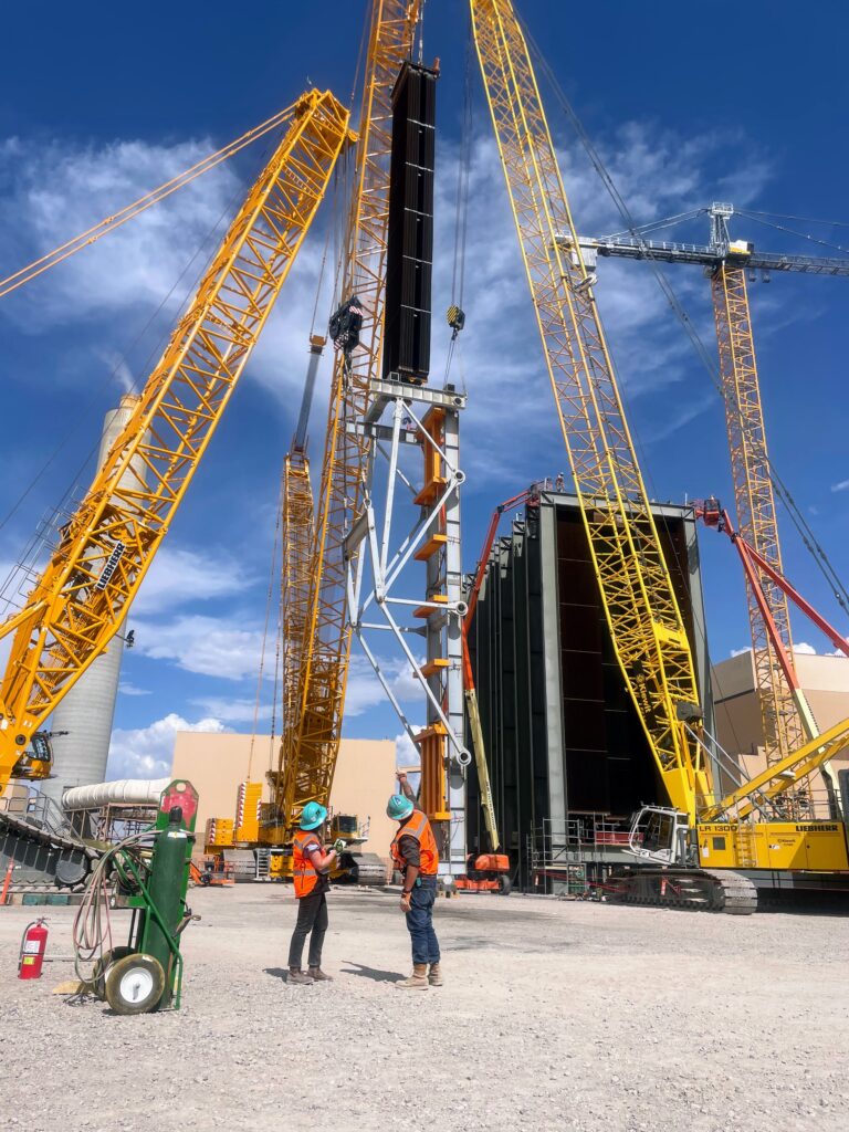 Image of construction workers supervising a crane lift