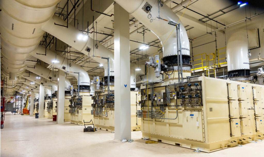 Des unités industrielles de filtration de l’air et des réseaux de conduits longent l’intérieur de l’installation souterraine de déchets radioactifs.