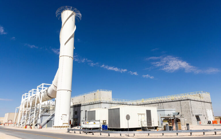 A 125-foot-tall exhaust stack rises above the Waste Isolation Pilot Plant (WIPP) in southeastern New Mexico, part of a new ventilation system supporting safer underground operations.