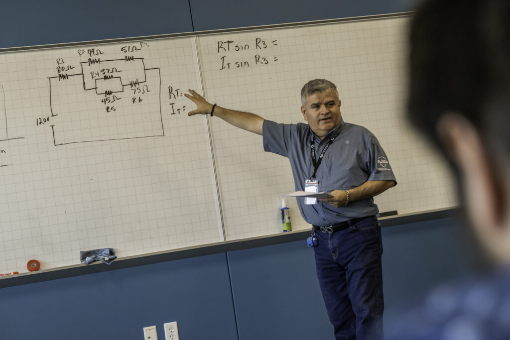 Un instructeur certifié par le NCCER anime une séance de formation en transport d’électricité en espagnol, veillant à ce que la langue ne constitue jamais un obstacle à l’apprentissage et à l’avancement professionnel.
