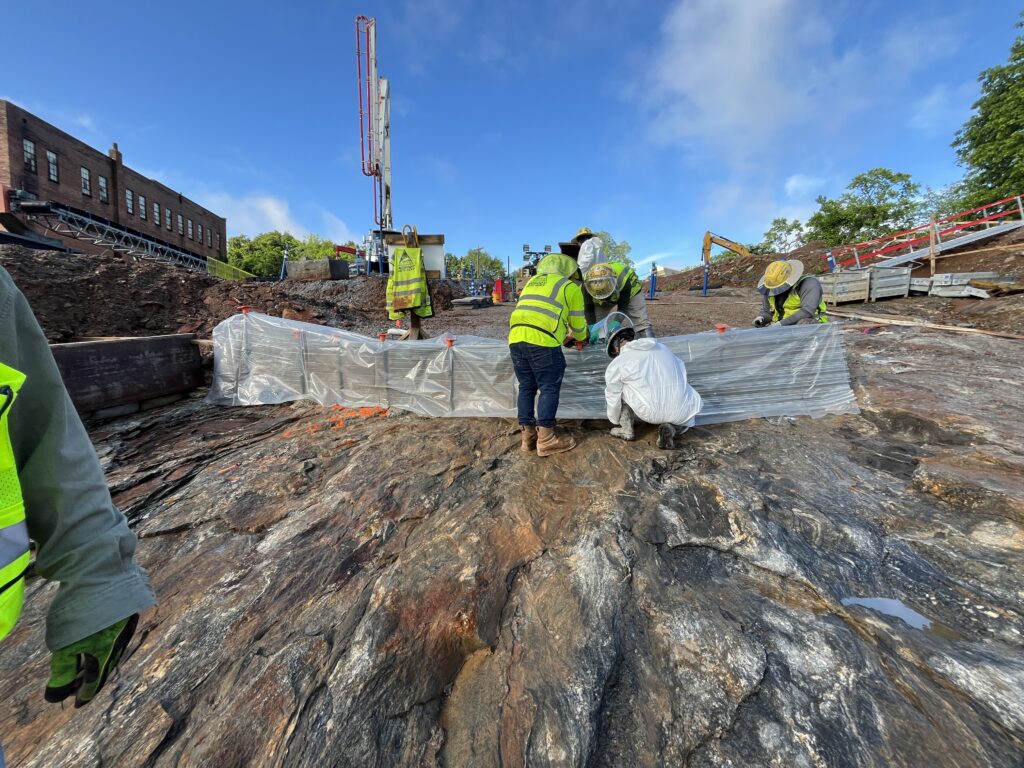 Crews construct a contraction joint on the rock foundation that will support the new dam.